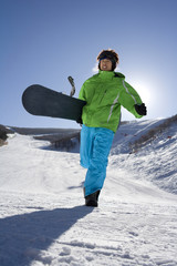 Young man with snowboard walking