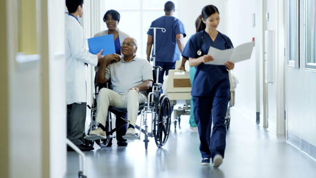 African American disabled male on wheelchair and wife in medical centre