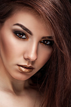 Close up Art beauty portrait. Fashion gold make up of beautiful