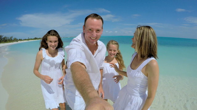 Selfie portrait of happy young Caucasian family on beach 
