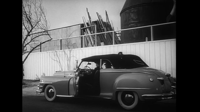 Man getting into car, 1940s