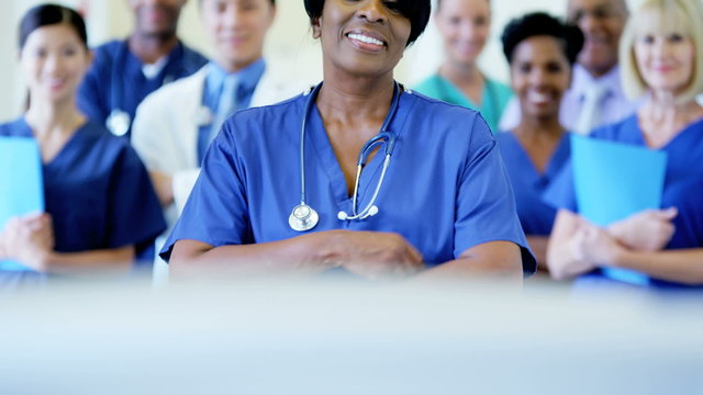 Portrait of confident African American female staff and team in medical centre