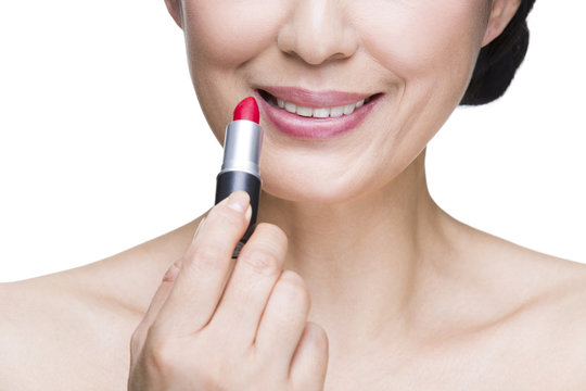 Beautiful Mature Woman Applying Lipstick