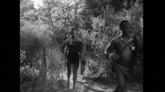 African tribesmen running through jungle