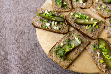 Homemade lard and pickled gherkin on a slices of bread. Traditional rural cuisine.