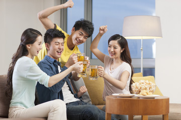 Cheerful young adults toasting with beer