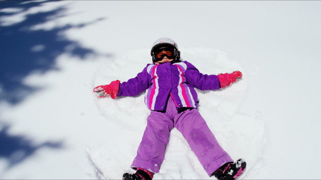 Caucasian young female child colourful clothes outdoor fun playing snow Aspen