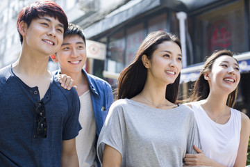 Young friends walking together on street