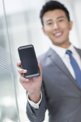 Young businessman showing smart phone