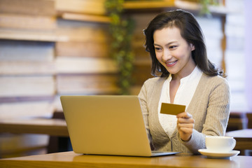 Young woman shopping online in cafe