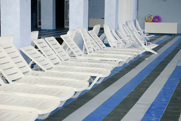 Many white empty chaise-longue