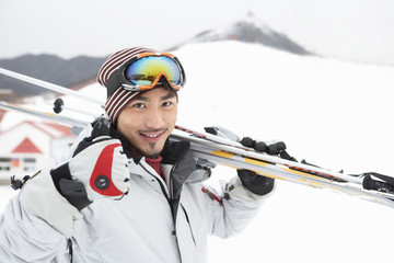 Man Holding Skis, Giving Thumbs Up