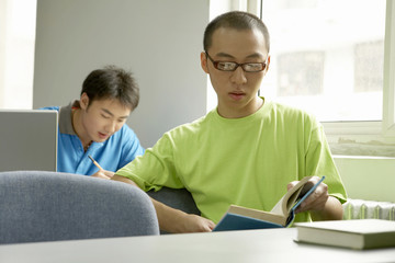 Student Sitting And Reading A Book