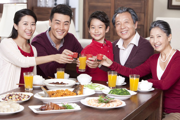 Family toasting at dinner table during Chinese New Year