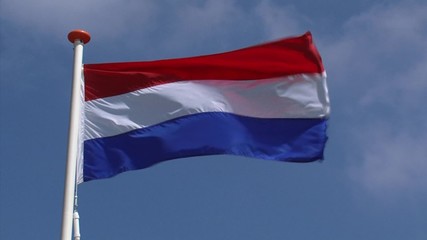 Dutch flag in blue sky waving in wind. The national flag of the Kingdom of The Netherlands is a horizontal tricolour of red, white, and blue is the oldest tricolor flag. - Powered by Adobe