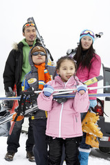 Young Family Preparing For A Day Skiing