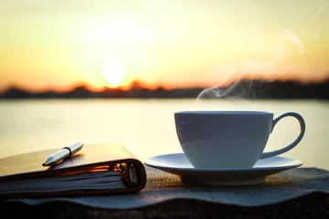 Zelfklevend Fotobehang Silhouetten van zonsopgang ochtendkoffie met een notitie en een pen © weerapat1003