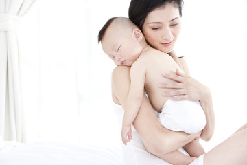 Gentle mother holding sleeping baby in arms