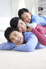 Young Chinese family lying on the floor close-up