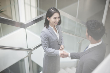 Business person shaking hands on the stairs