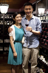 Young couple tasting wine in cellar