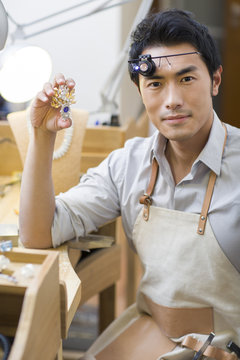 Male jeweler holding a brooch