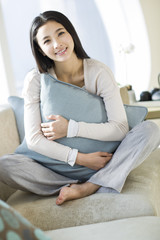 Happy young woman sitting on sofa