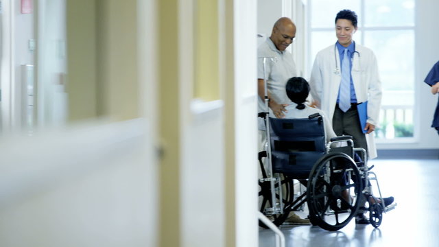 African American disability female on wheelchair and husband in medical center