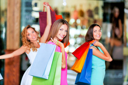 Beautiful young women with bags in shopping center