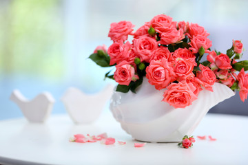 Beautiful rose in vase on table in room
