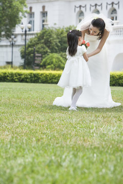 A young flower girl with the bride after a wedding