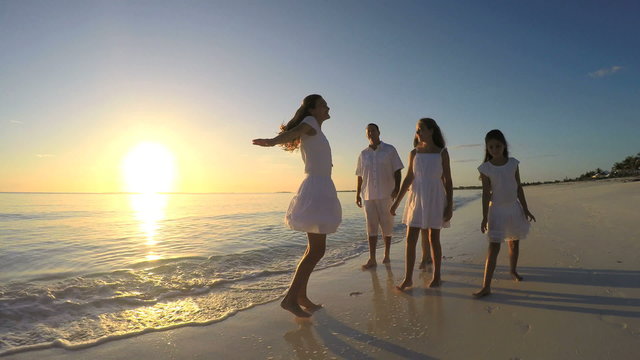 Caucasian barefoot family wearing white clothes on the beach 