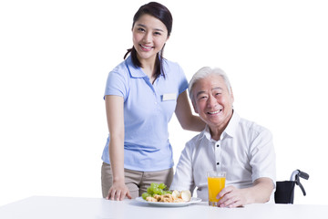 Disabled senior man having breakfast in nursing home
