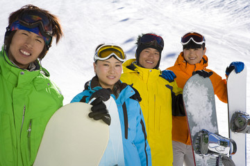 Four young people with snowboards