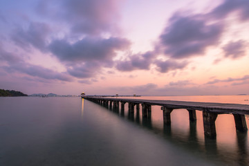 Fototapeta na wymiar Wooded bridge in the port between sunrise