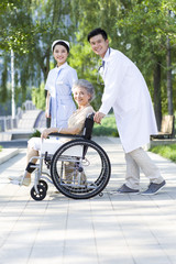 Doctor, nurse and wheelchair bound patient