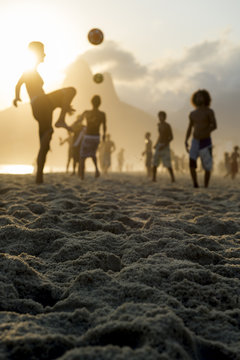 Sunset silhouettes playing altinho futebol beach football kick-ups soccer ball Ipanema Beach Rio de Janeiro Brazil