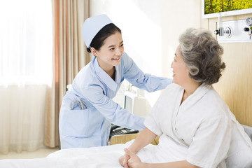 Fototapeta premium Nurse taking care of senior woman in hospital