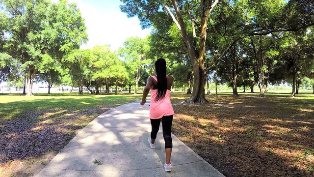 Young African American fitness girl power walking outdoor