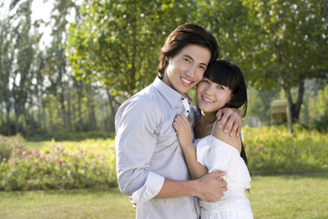 Fototapeta premium Young couple embracing each other in park