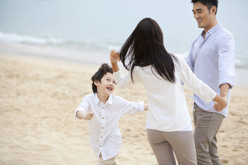 Excited young family having fun on the beach of Repulse Bay, Hong Kong