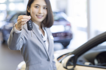 Saleswoman showing car key