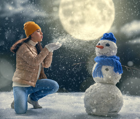 woman plaing with a snowman