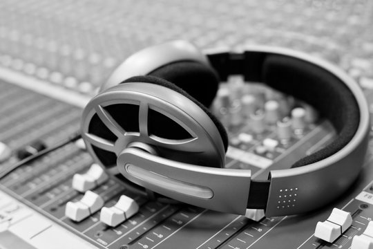  Headphones lying on the mixing console in black and white