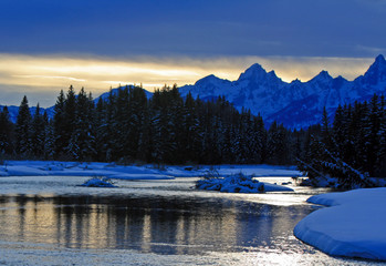 Snake River at twilight below the Grand Teton mountain range peaks in the Central Rocky mountains in Grand Tetons National Park in Wyoming USA near the town of Jackson during the winter