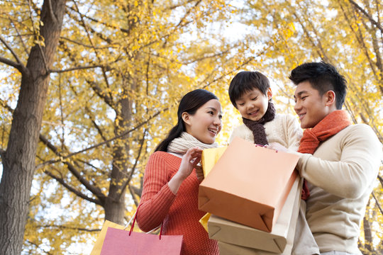 Young Family Shopping In Autumn