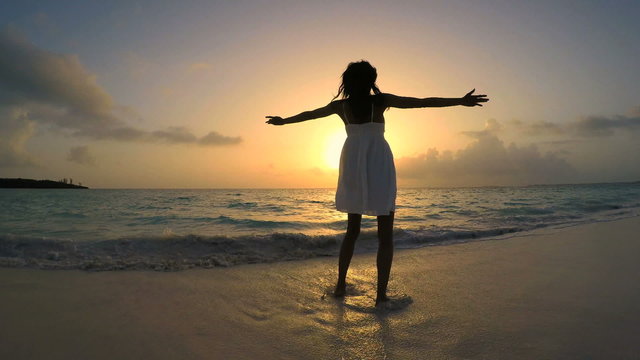 African American girl in white sundress barefoot on beach