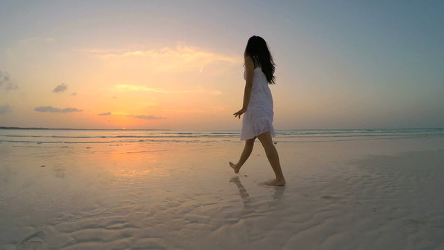 Beautiful Asian Chinese girl in white dress on ocean beach
