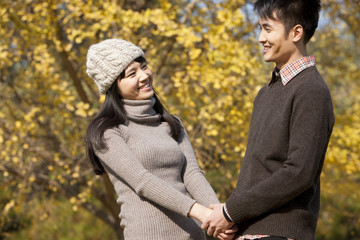 Happy young couple in love holding hands outdoors in autumn