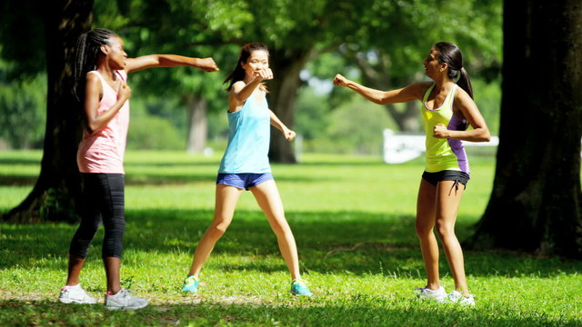 Young happy multi ethnic American females doing fitness routine outdoor